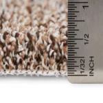 Close-up of Berber carpet pile with ruler measurement.