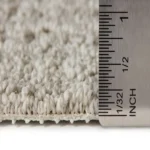 Ruler measuring the pile height of beige carpet