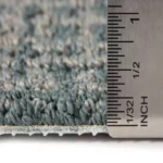 Ruler measuring the pile height of blue-grey carpet