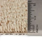 Ruler measuring the thickness of cream carpet
